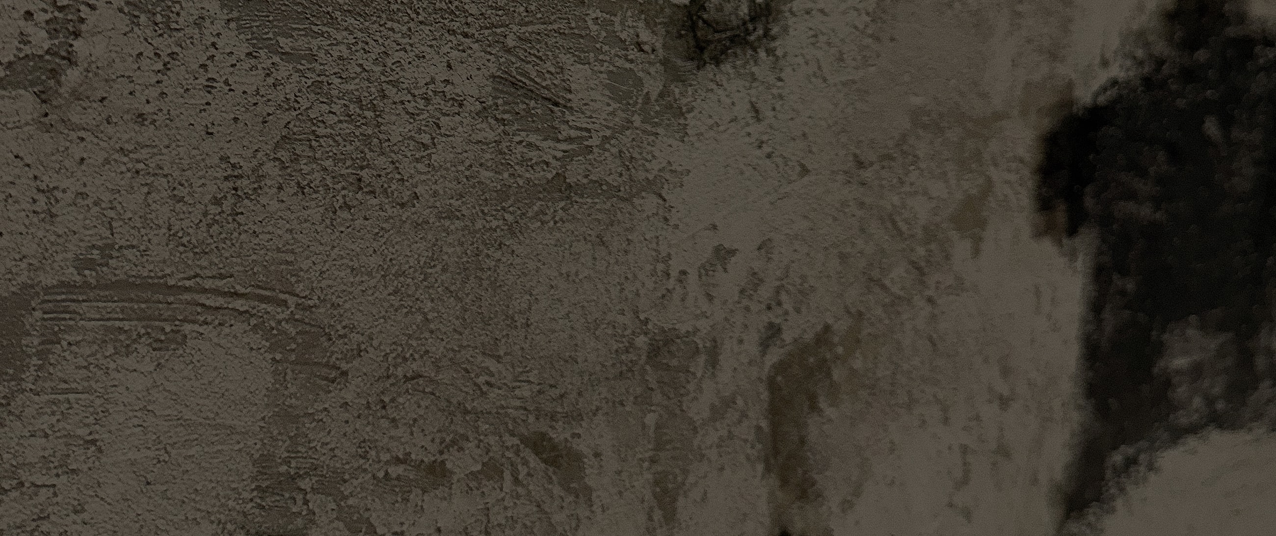 Textured wall with dark and light areas.
