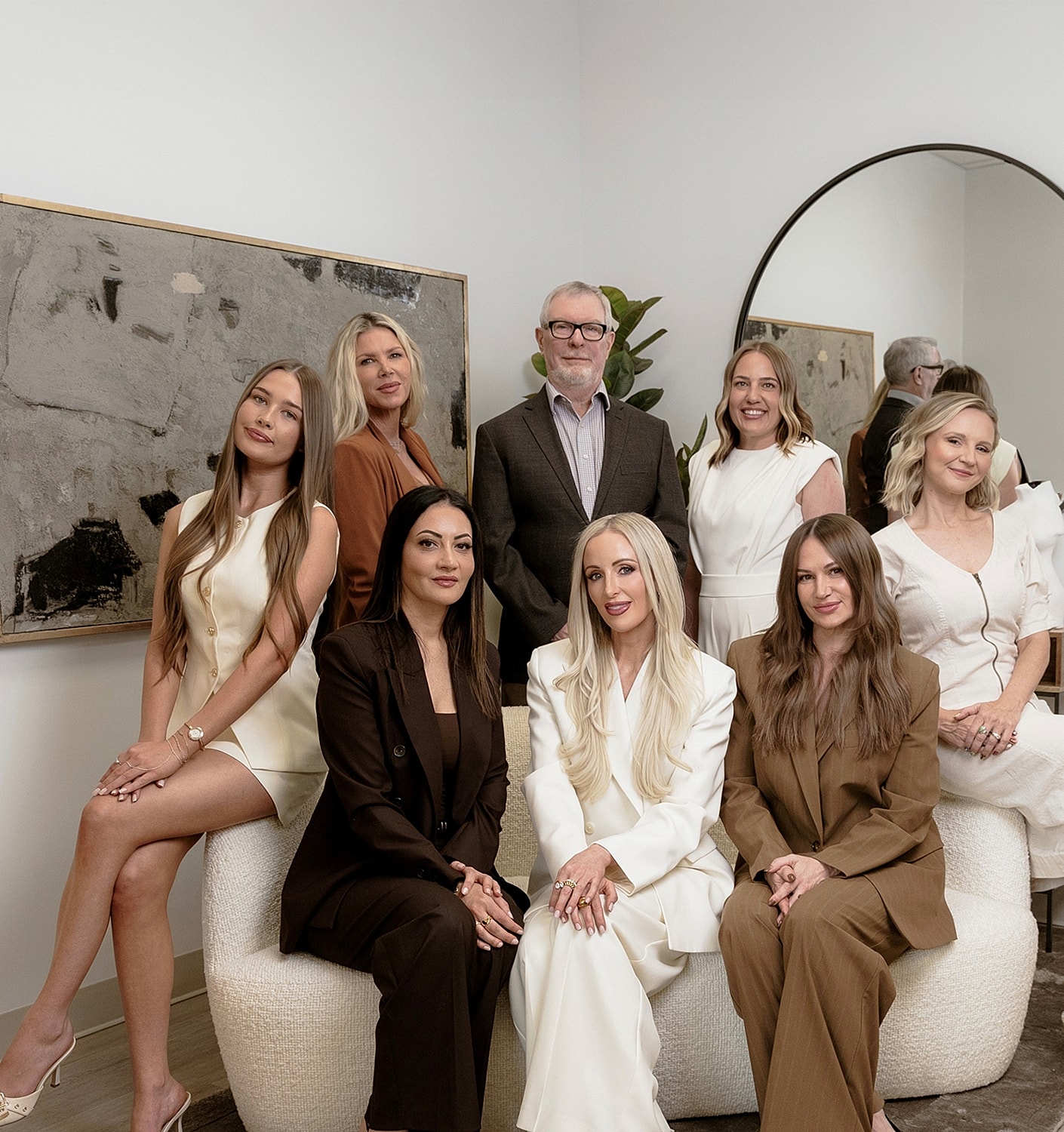 Group portrait of nine professionals in stylish attire.